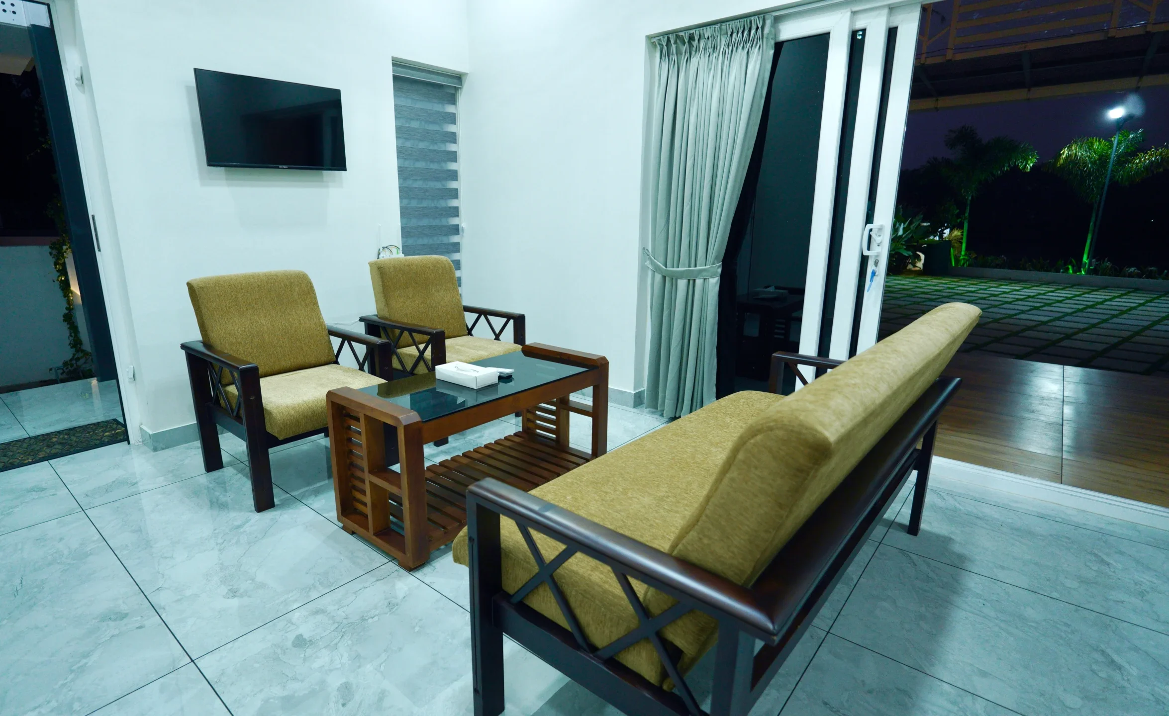 Modern villa interior at night with lighting and outdoor dining space