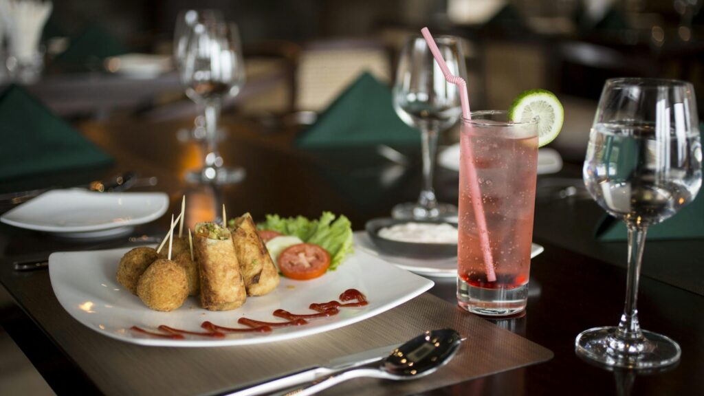Delicious plated meal with savory snacks and a refreshing drink at a fine dining restaurant.