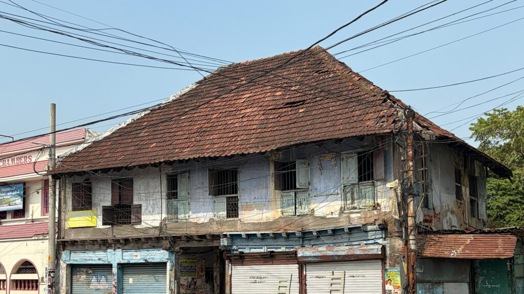 An aged colonial building with rusted shutters in Kochi, Kerala, India, showing rustic charm.