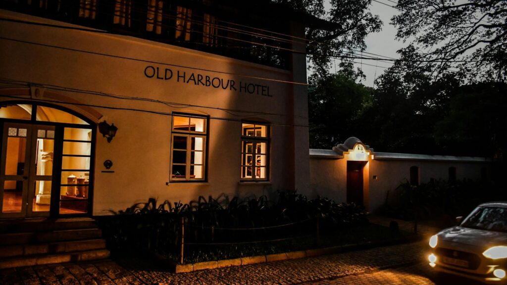 Old Harbour Hotel illuminated at dusk with vintage charm and intricate architecture.weekend getaway near kochi